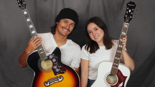 Rudy and Bella Seated holding guitars