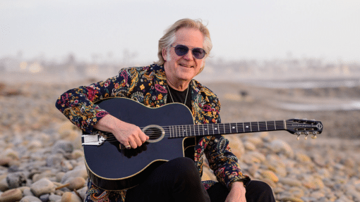 John Jorgenson on the beach with guitar
