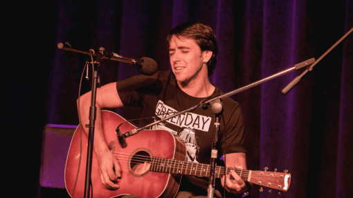 Open Mic Night performer singing with guitar