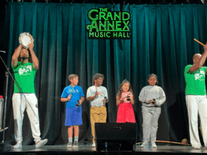 Ballet Folclórico do Brasil teaching rhythms to students on stage during a Meet the Music event at the Grand Annex