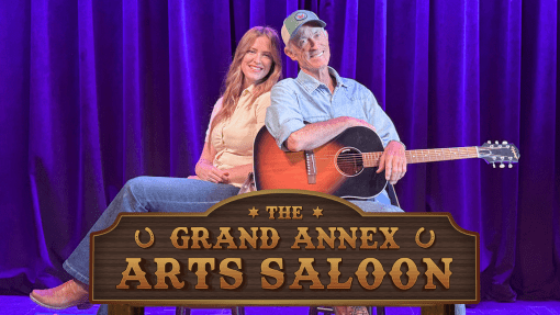 Emily and Chris Huff with the Grand Annex Arts Saloon wooden sign