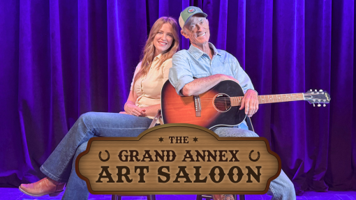 Emily & Chris Huff posing on the Annex stage with he Grand Annex Art Saloon sign